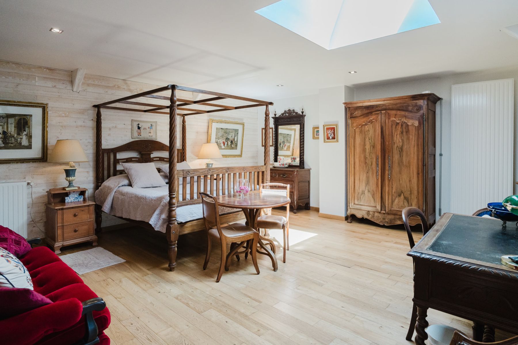 Vue d'ensemble de la Chambre Double Confort à Erquy : lit à baldaquin, coin salon et armoire bretonne