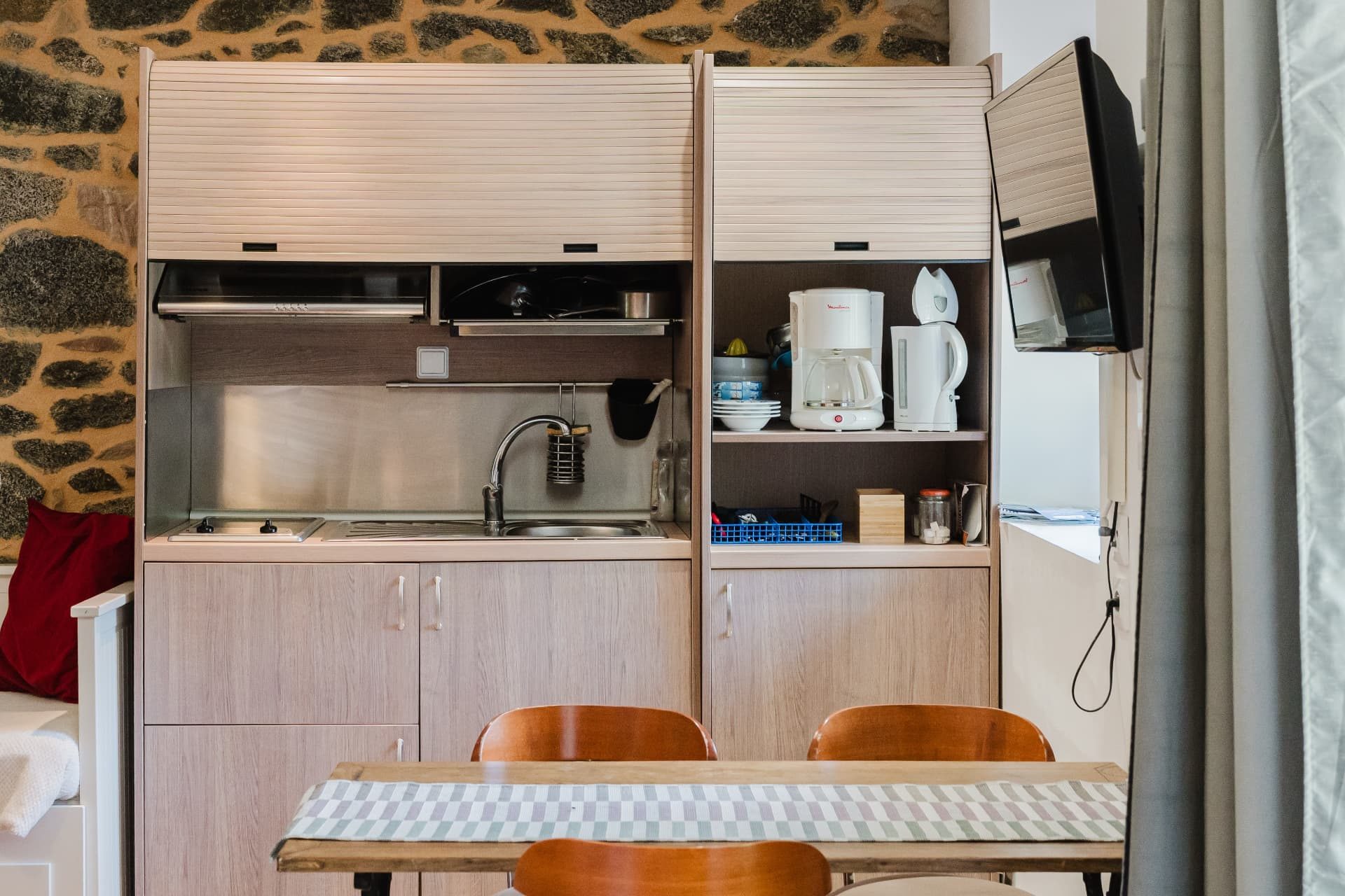 Kitchenette équipée avec plaques, évier, cafetière et bouilloire