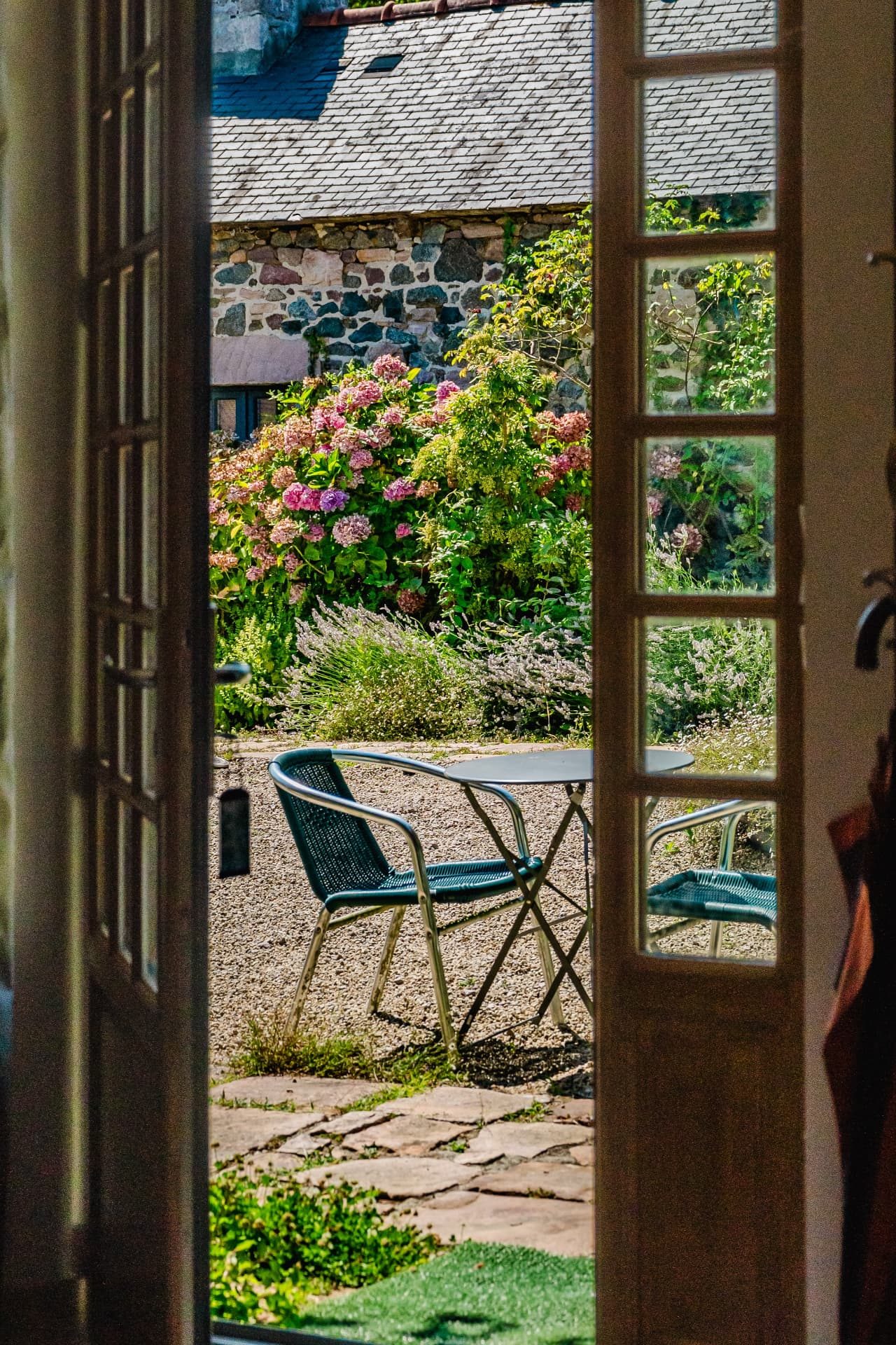 Vue depuis la chambre sur la cour fleurie d'hortensias et de lavande